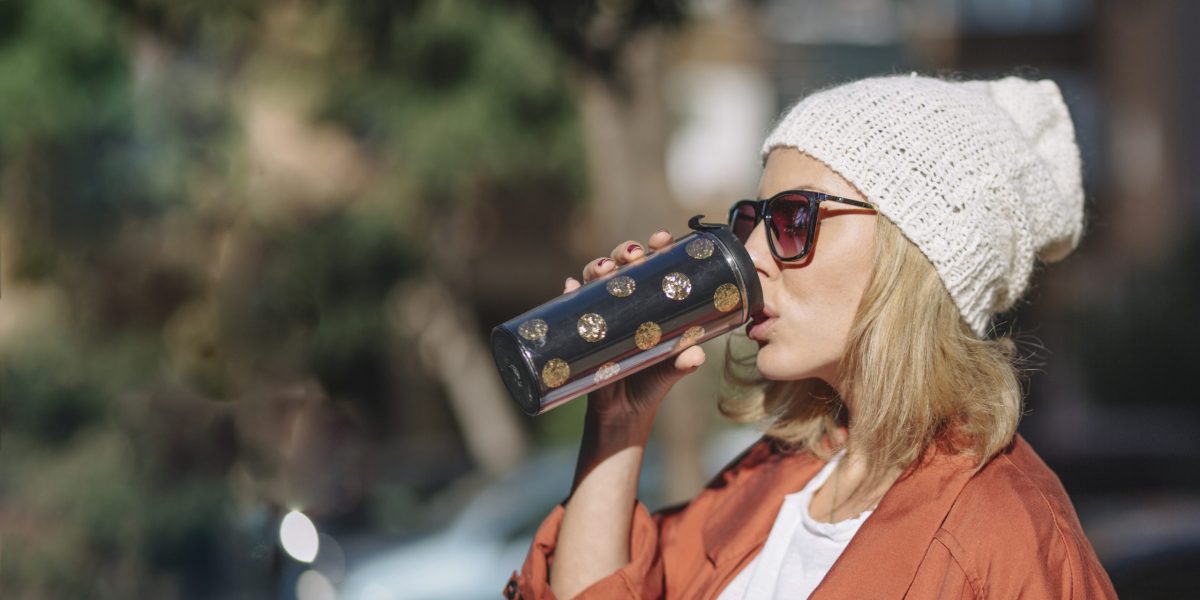 pretty-woman-enjoying-beverage-street